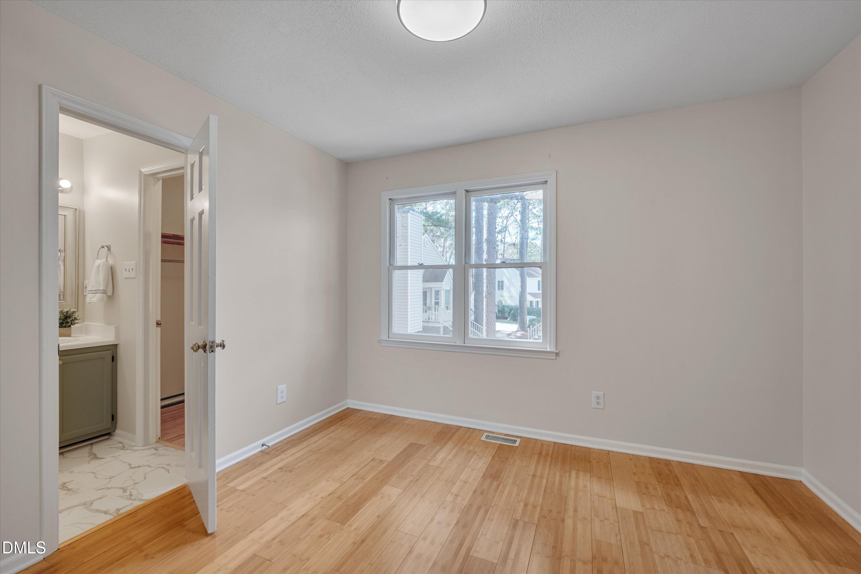 6528 Hearthstone Drive Raleigh, NC 27615 - Photo 21 of 32 an empty room with wooden floor and windows