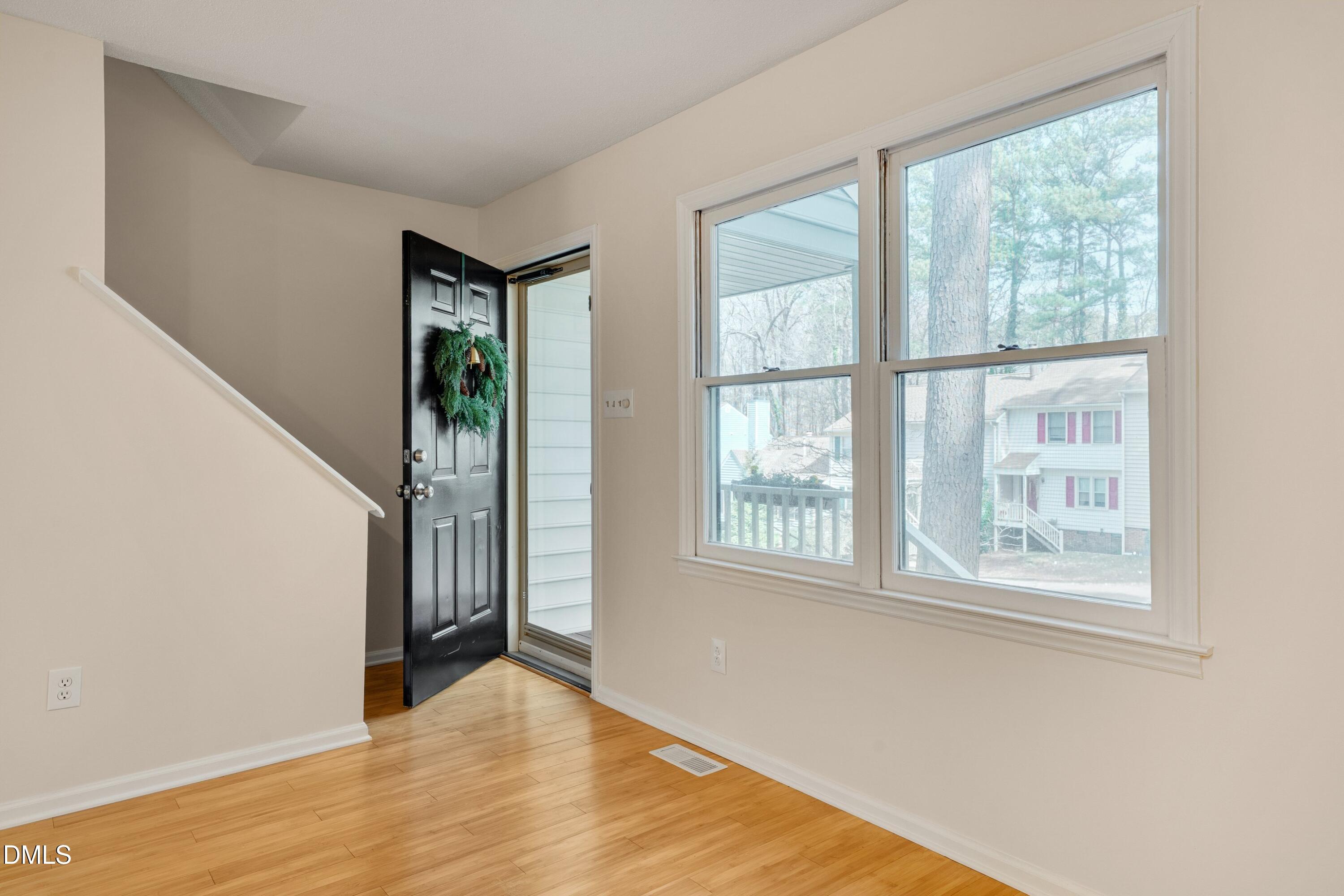 6528 Hearthstone Drive Raleigh, NC 27615 - Photo 7 of 32 a view of an empty room with wooden floor and a window