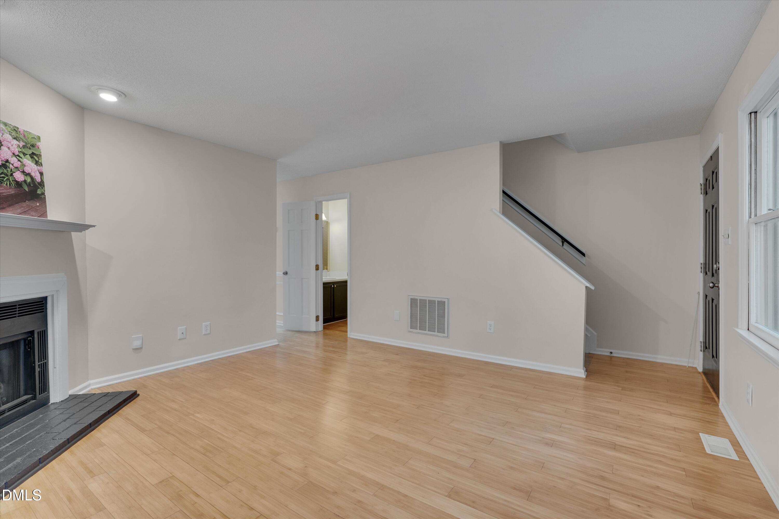 6528 Hearthstone Drive Raleigh, NC 27615 - Photo 8 of 32 a view of an empty room with wooden floor and a fireplace