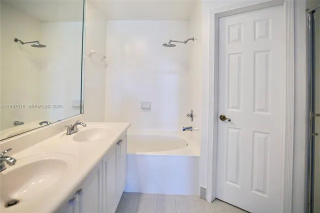 a bathroom with a tub sink and mirror