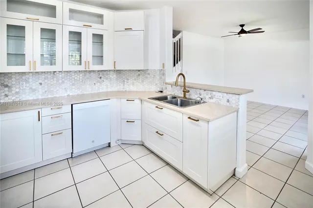 a white kitchen with a sink and cabinets