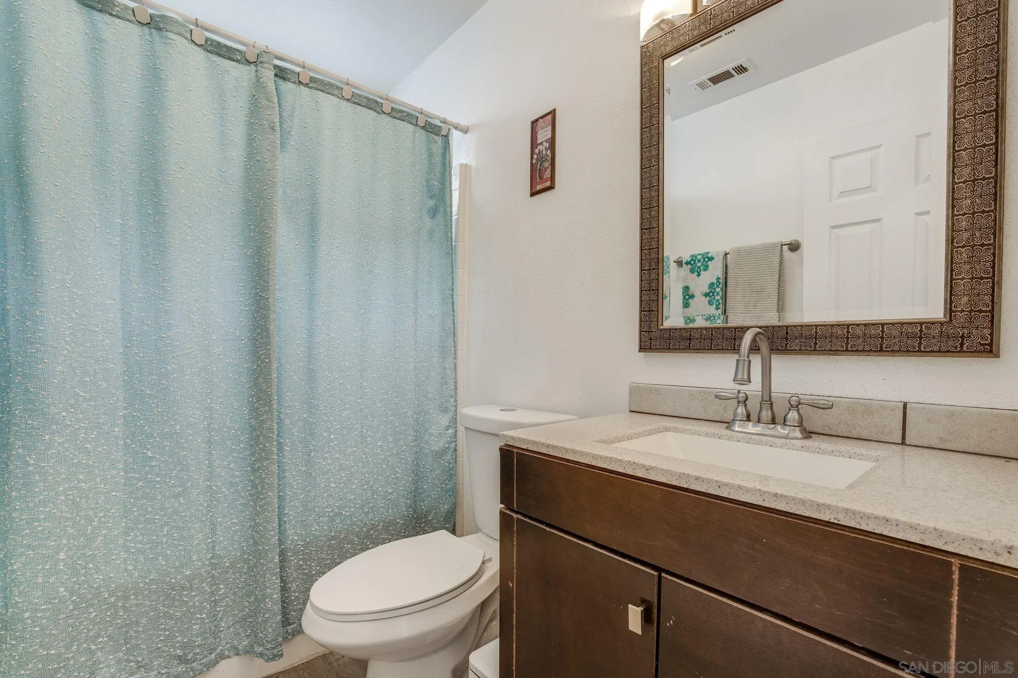 1616 Gold Run Road Chula Vista, CA 91913 - Photo 14 of 35 a bathroom with a sink a toilet a mirror and shower curtain