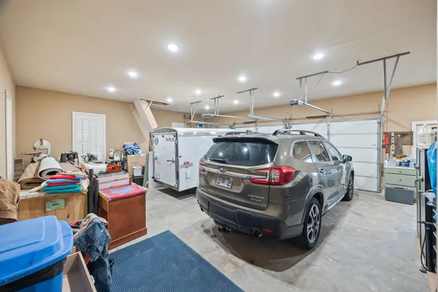 a kitchen with stainless steel appliances granite countertop a refrigerator a sink dishwasher a dining table and chairs with wooden floor