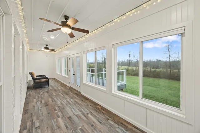 a view of empty room with wooden floor and fan