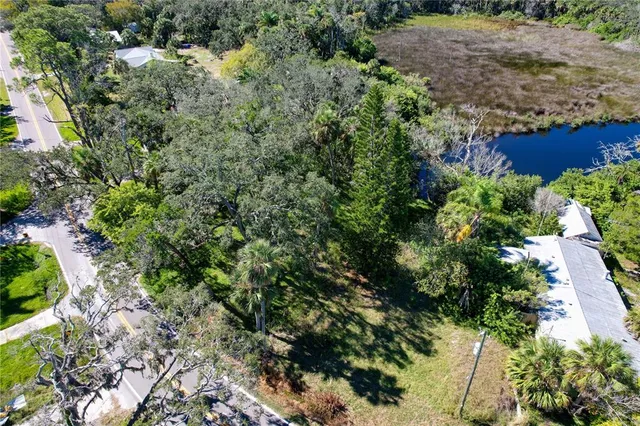 an aerial view of residential house with outdoor space and trees all around