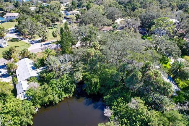 an aerial view of residential house with outdoor space and trees all around