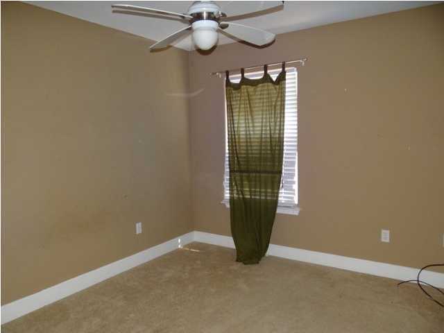 70 Cypress Lane Freeport, FL 32439 - Photo 17 of 21 a view of an empty room with a chandelier fan and a window