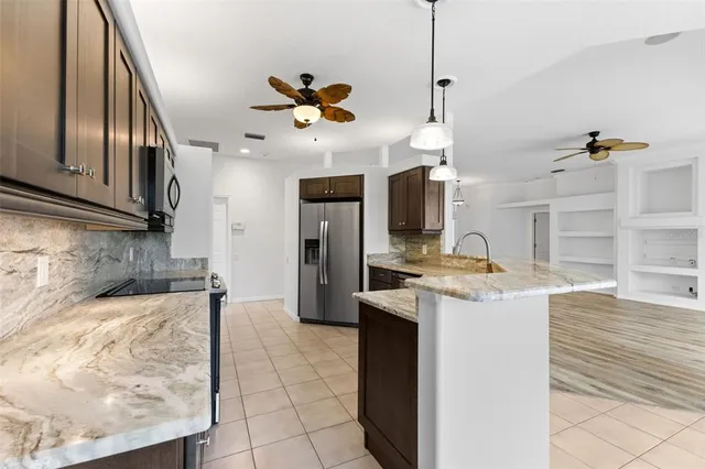 a kitchen with stainless steel appliances granite countertop a refrigerator a stove top oven a sink and dishwasher