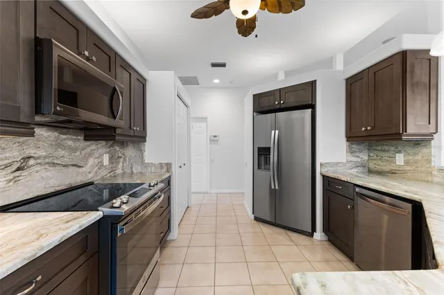 a kitchen with a sink and a stove top oven with granite countertops