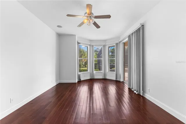 a view of wooden floor and a chandelier fan in a room