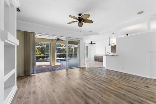 a view of a kitchen with wooden floor a sink a refrigerator and window