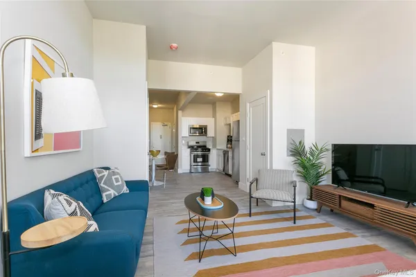 a kitchen with stainless steel appliances kitchen island granite countertop a refrigerator a stove a kitchen island and chairs with wooden floor