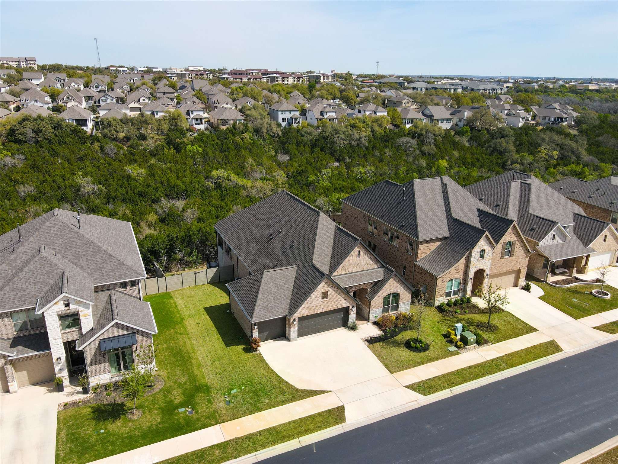 an aerial view of residential houses with outdoor space and trees