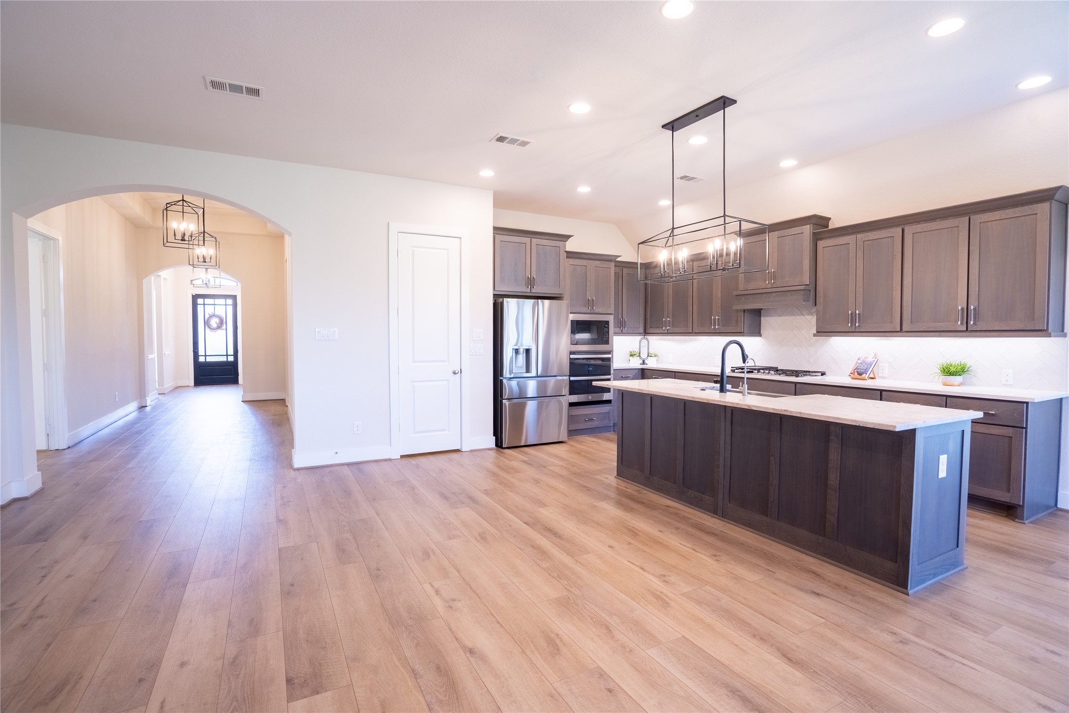 1309 Spring Gulch Lane Georgetown, TX 78628 - Photo 16 of 27 a kitchen with stainless steel appliances kitchen island granite countertop a refrigerator a oven a sink and dishwasher with wooden floor