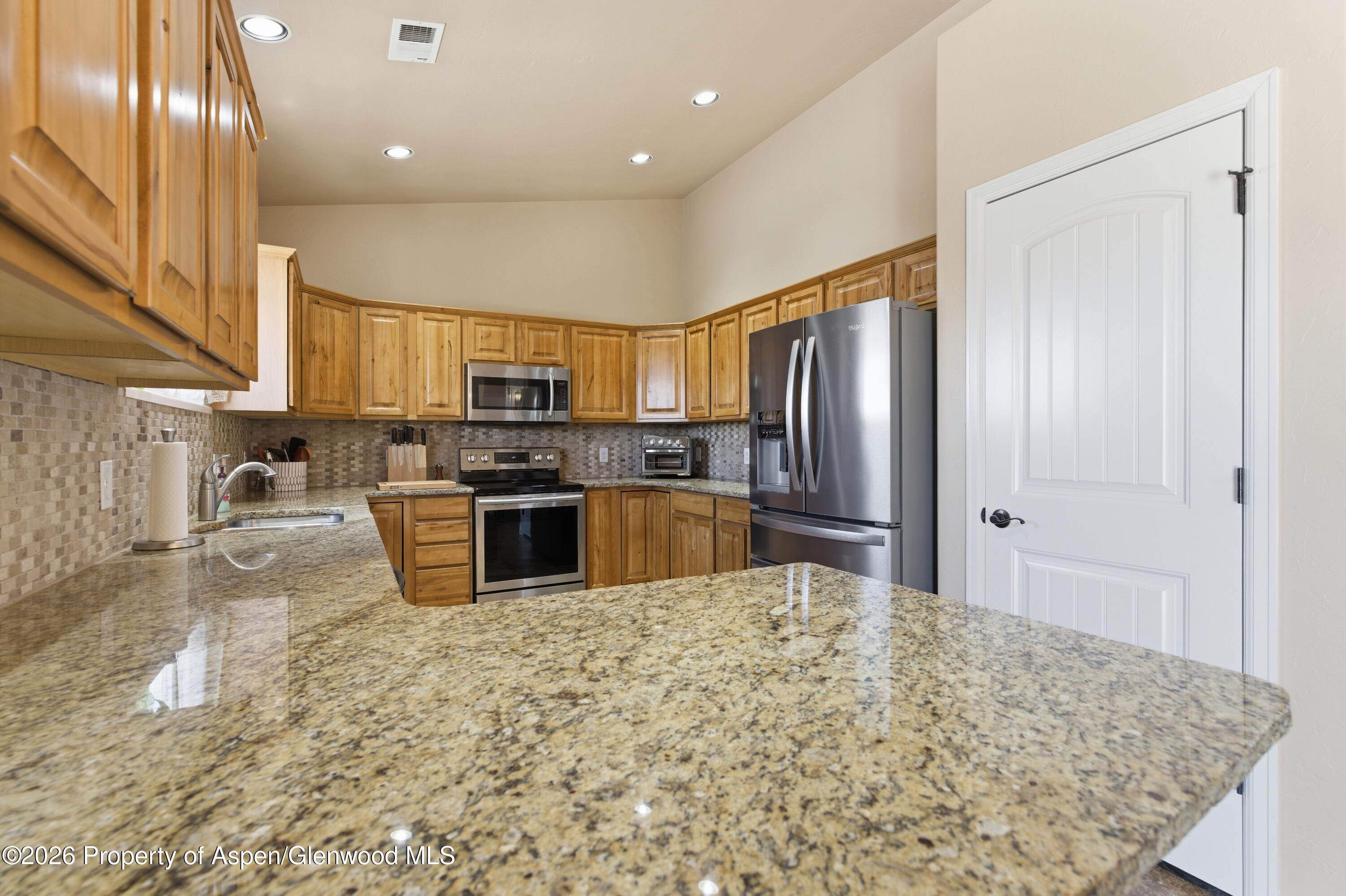 1081 20 Road Fruita, CO 81521 - Photo 7 of 43 a kitchen with stainless steel appliances granite countertop a refrigerator sink and stove