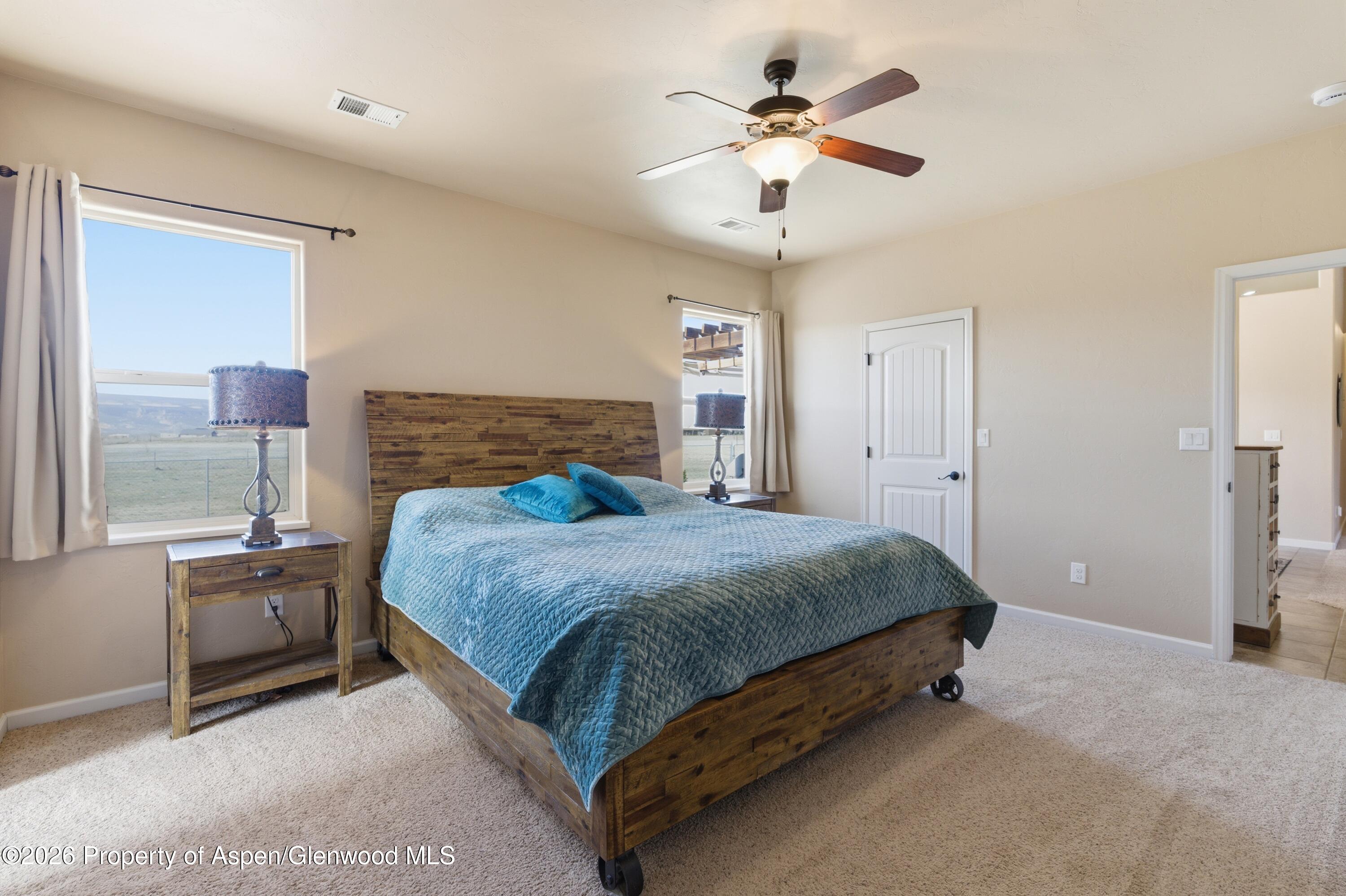 1081 20 Road Fruita, CO 81521 - Photo 9 of 43 a spacious bedroom with a bed and a chandelier
