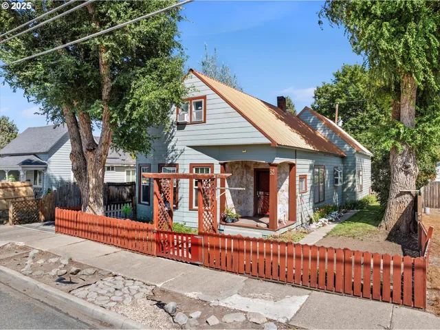 a view of a house with wooden fence next to a road