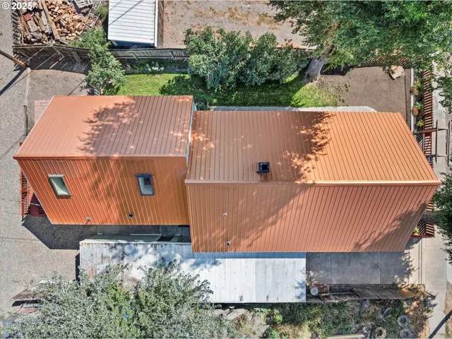an aerial view of a house with a yard and a large tree