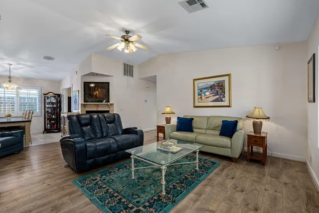 a living room with furniture a flat screen tv and kitchen view