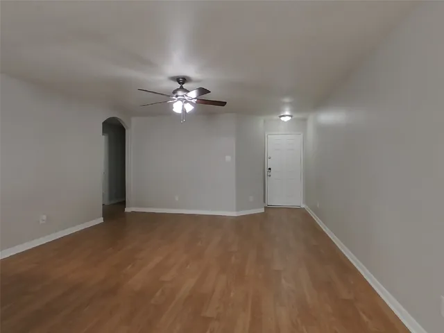 a view of an empty room with a chandelier fan