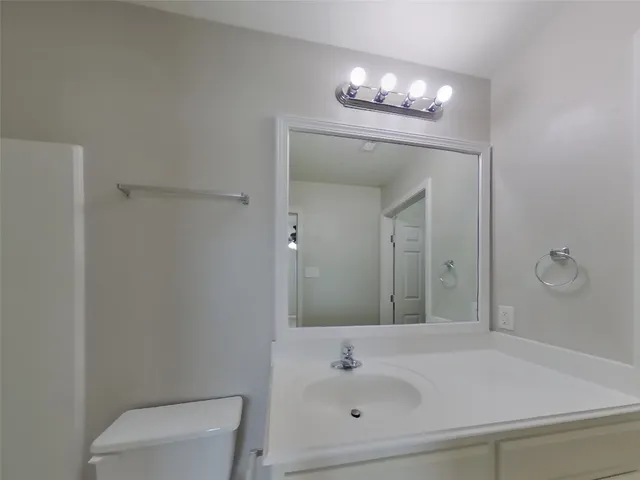 a bathroom with a sink a light fixture and a mirror
