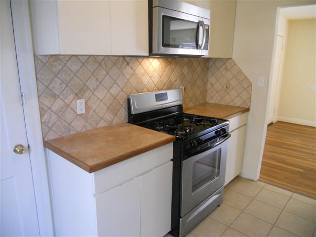 2511 Enfield Road, Unit B Austin, TX 78703 - Photo 5 of 11 A well-appointed kitchen features a stainless steel range and microwave, complemented by warm-toned countertops.