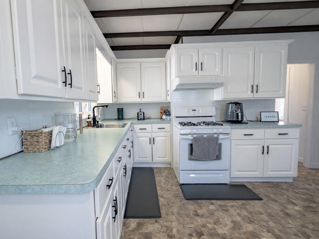 10 Guild Road Saugus, MA 01906 - Photo 12 of 32 a kitchen with granite countertop a sink a stove and cabinets
