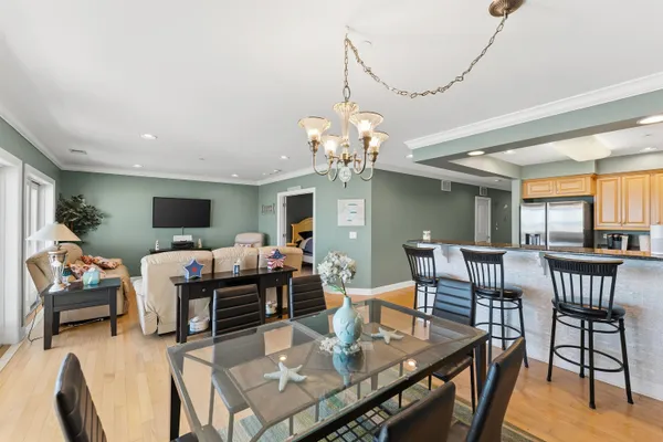 a living room with furniture a chandelier and a dining table