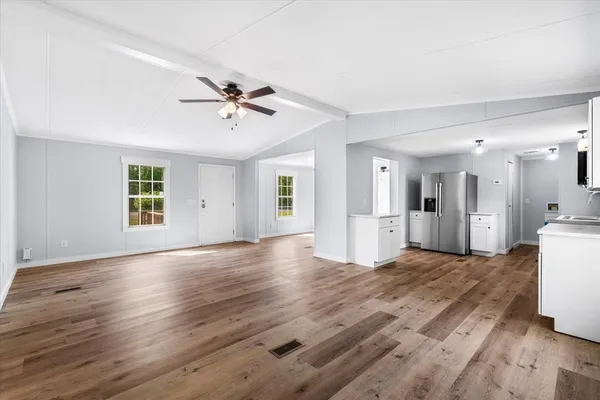 a view of a livingroom with wooden floor and a ceiling fan