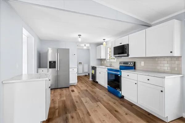 a kitchen with stainless steel appliances a refrigerator sink and white cabinets
