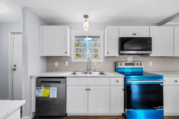 a kitchen with a sink stove and microwave