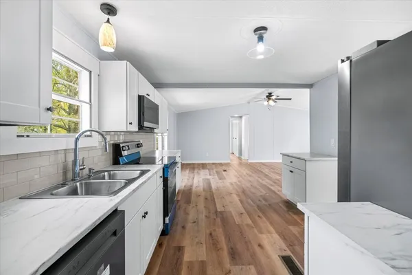 a kitchen with a sink a counter top space stainless steel appliances and a window