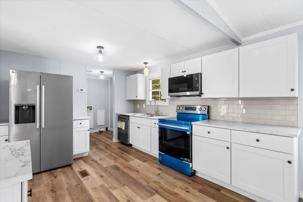 a kitchen with granite countertop a refrigerator stove top oven and sink