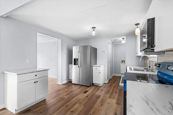 a large kitchen with stainless steel appliances a refrigerator and a stove top oven