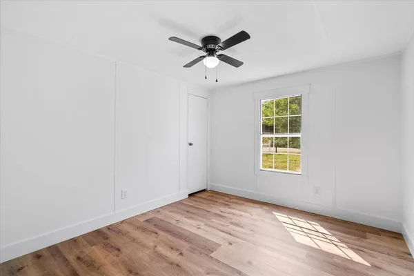 an empty room with a window and ceiling fan