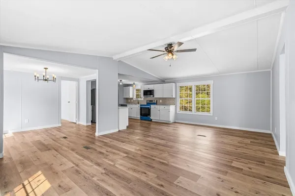 a view of a kitchen with wooden floor and a ceiling fan