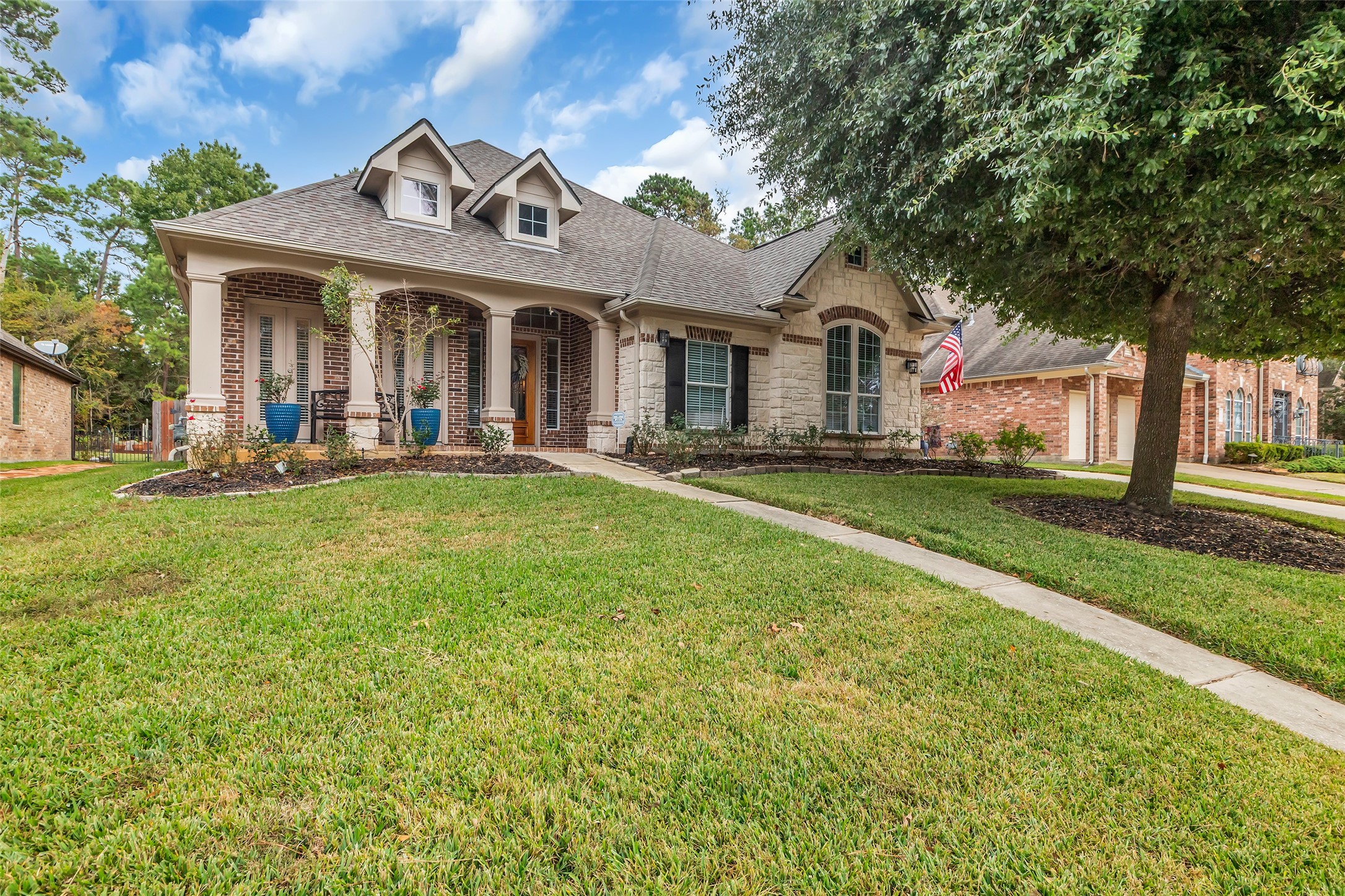 1622 Beau Rivage Conroe, TX 77304 - Photo 1 of 37 a front view of a house with a garden and trees