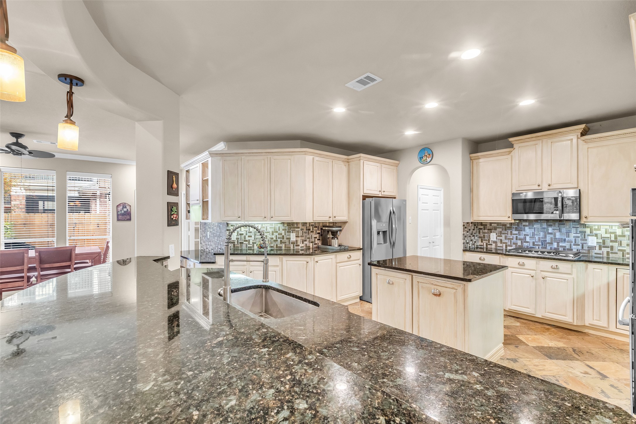 1622 Beau Rivage Conroe, TX 77304 - Photo 9 of 37 a large kitchen with kitchen island a large counter top stainless steel appliances and cabinets