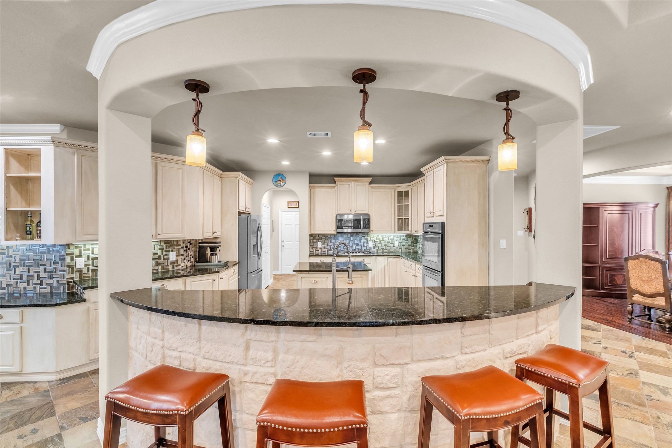 1622 Beau Rivage Conroe, TX 77304 - Photo 10 of 37 a kitchen with stainless steel appliances granite countertop a kitchen island a table and chairs