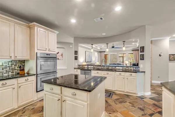 a kitchen with stainless steel appliances granite countertop a sink stove and refrigerator