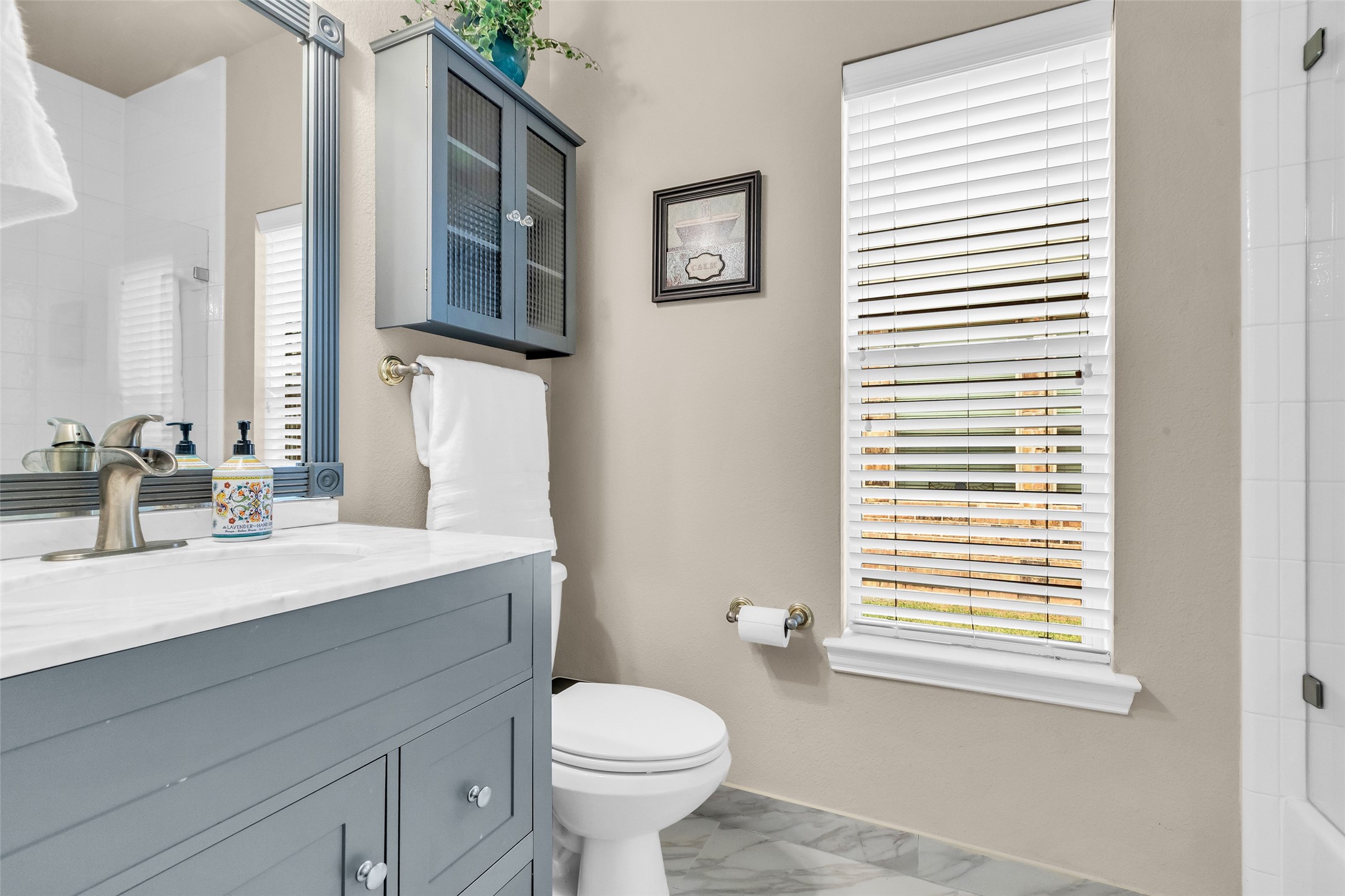 1622 Beau Rivage Conroe, TX 77304 - Photo 5 of 37 a bathroom with a sink a toilet and a mirror