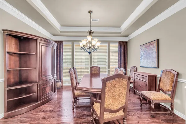 a view of a dining room with furniture a chandelier and wooden floor