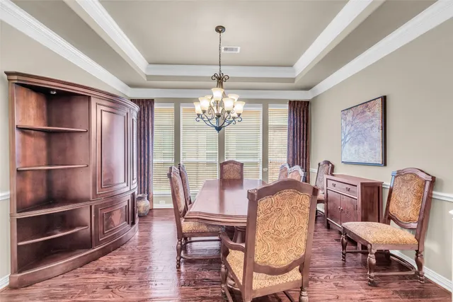 a view of a dining room with furniture a chandelier and wooden floor