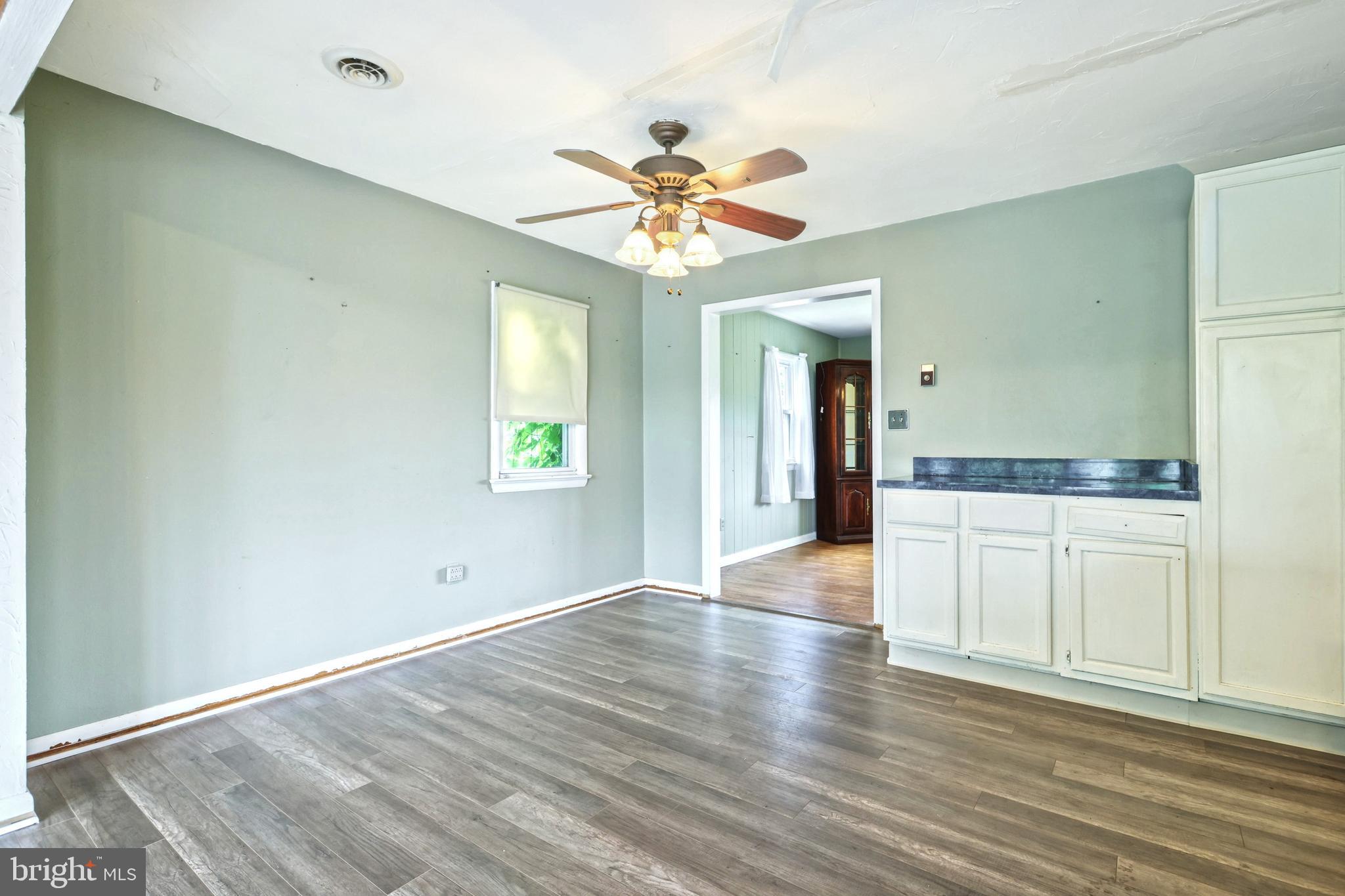 147 Mud College Road Littlestown, PA 17340 - Photo 14 of 43 an empty room with wooden floor chandelier fan and windows