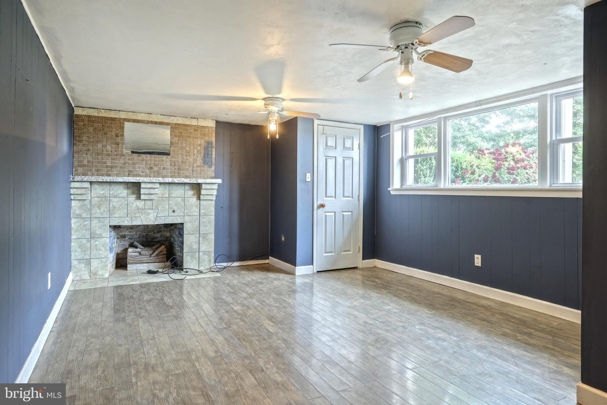 147 Mud College Road Littlestown, PA 17340 - Photo 23 of 43 wooden floor fireplace and windows in an empty room
