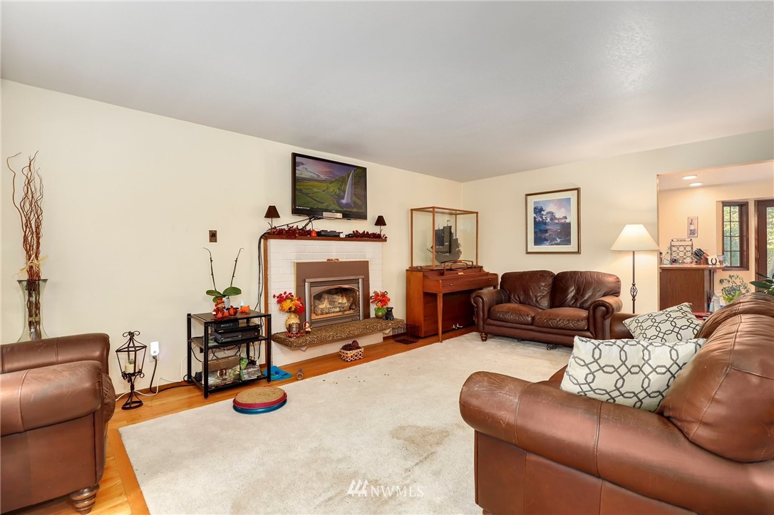 4313 212th Street Southeast Bothell, WA 98021 - Photo 7 of 40 a living room with furniture a fireplace and a flat screen tv