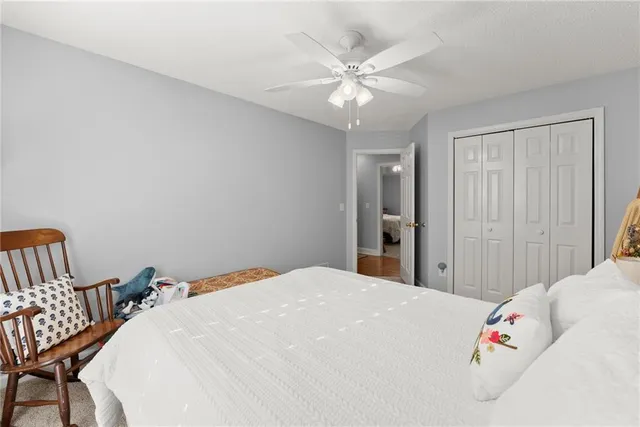 a bedroom with a bed and a lamp on dresser