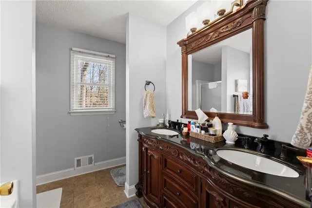 a walk in closet with wooden floor