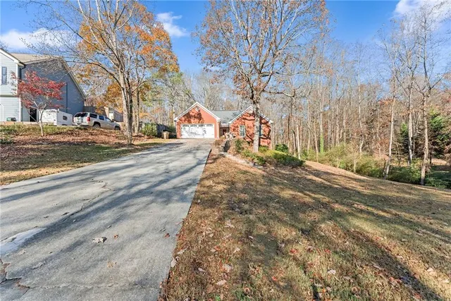 a front view of a house with large trees