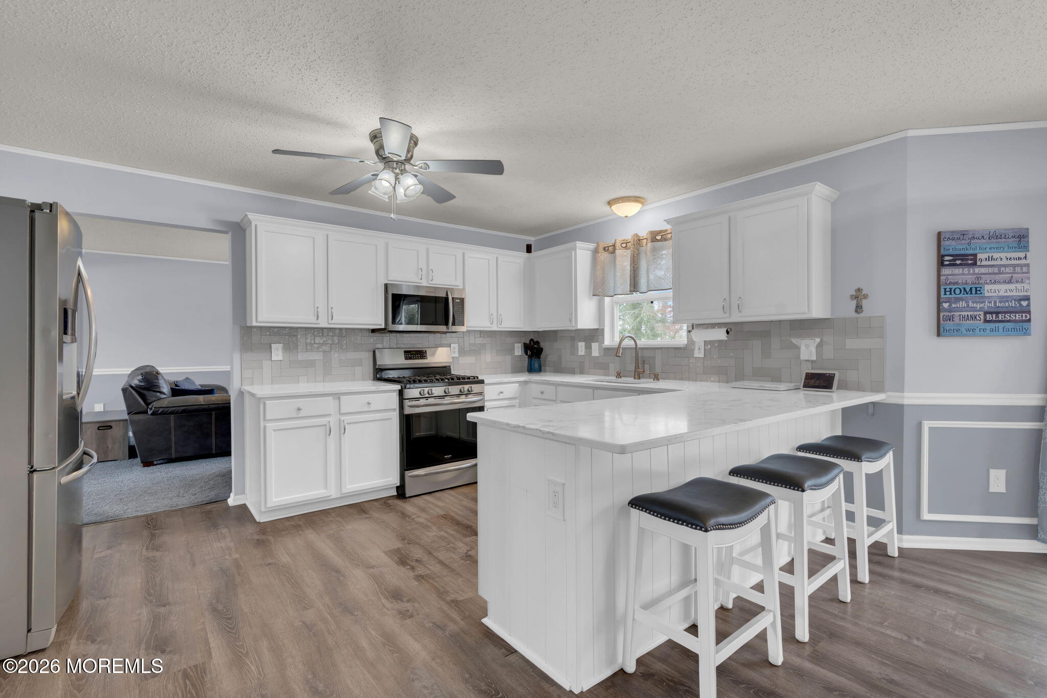 93 West Shenendoah Road Howell, NJ 07731 - Photo 3 of 30 a kitchen with granite countertop white cabinets a sink dishwasher and a stove with wooden floor